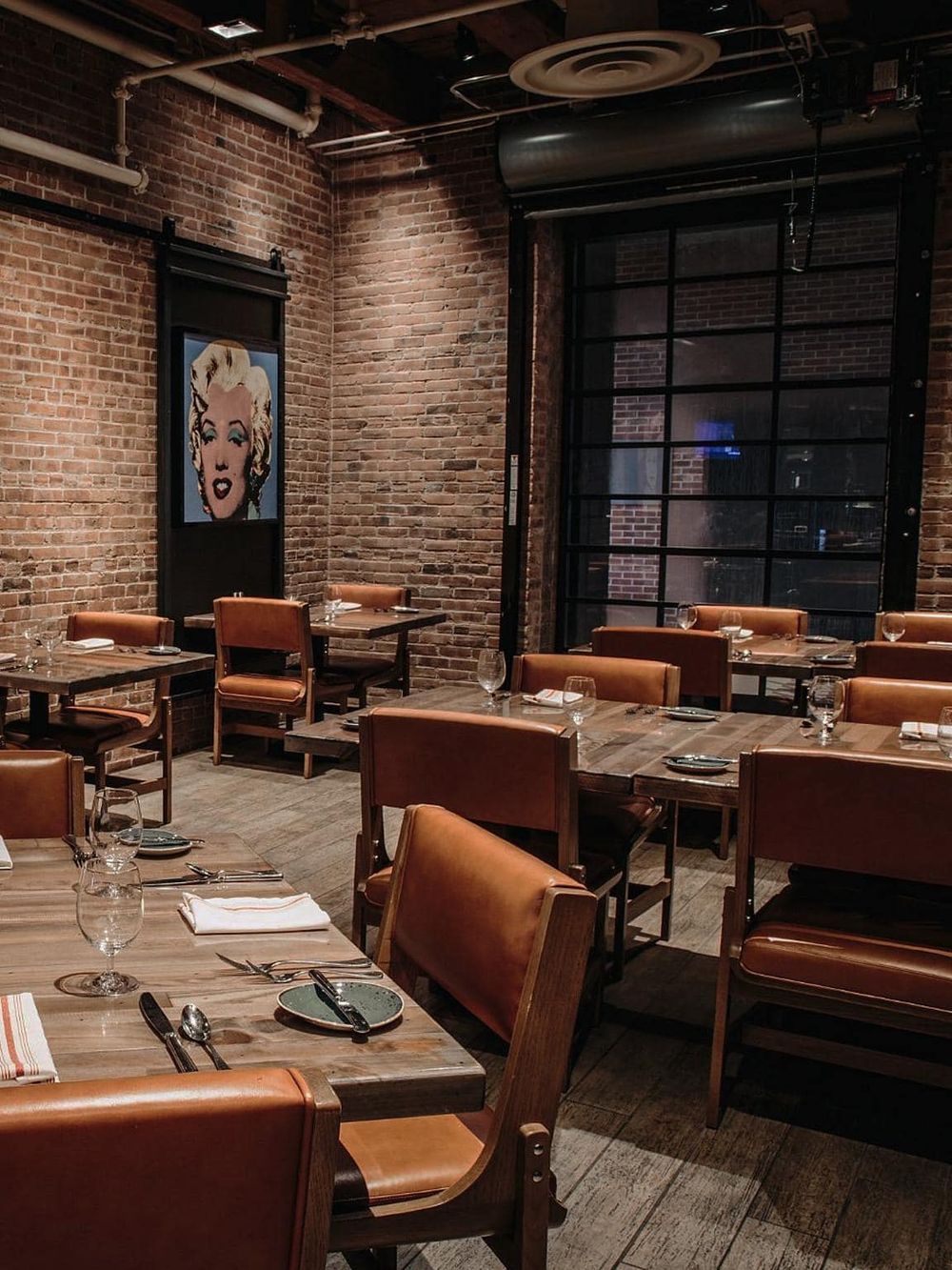 Cozy modern restaurant interior with brick walls and stylish decor, perfect for dining and socializing.