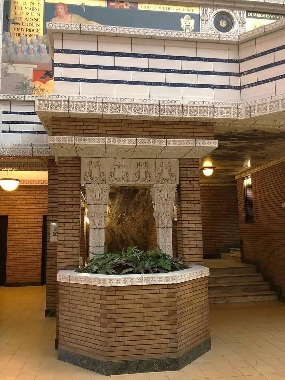 Historic brick building with ornate architectural details and indoor plants.