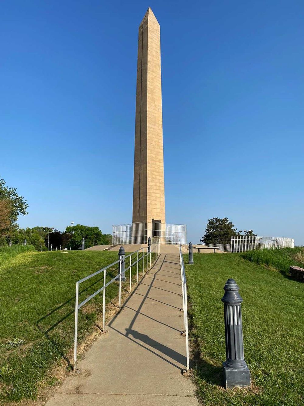 Historic Washington Monument in Baltimore, Maryland, with clear blue sky, accessible walkway, and well-maintained grounds.