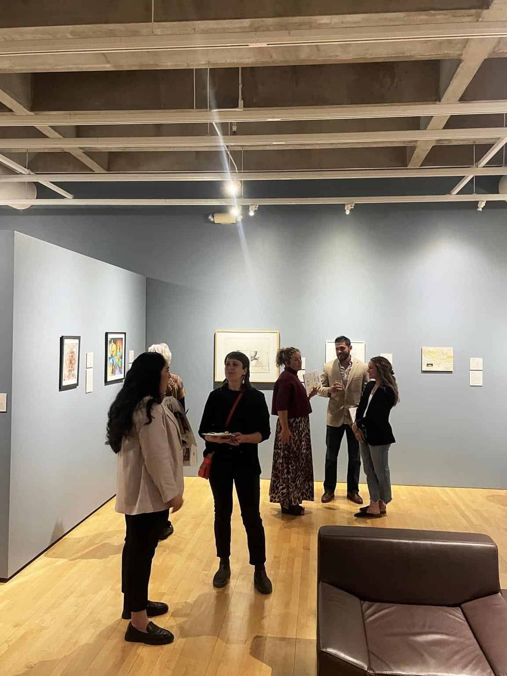 Vibrant art gallery with diverse visitors engaging with contemporary artworks in a modern museum space.