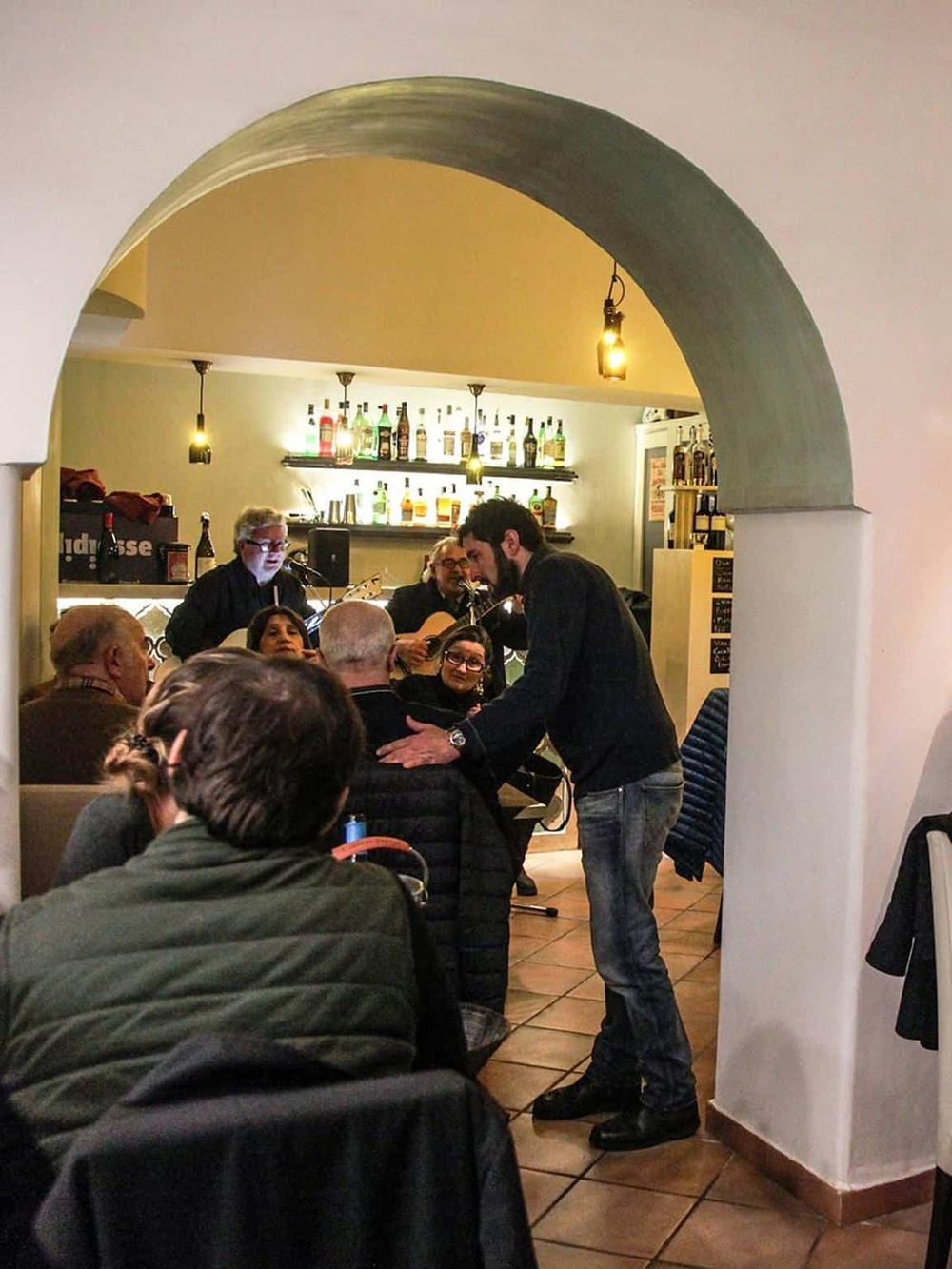 Live acoustic music performance at a cozy restaurant or bar, with engaging audience and friendly atmosphere.