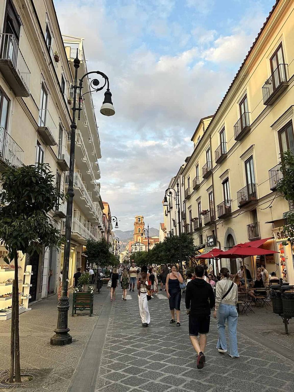 Bustling pedestrian street in a historic European city with shops and cafes.