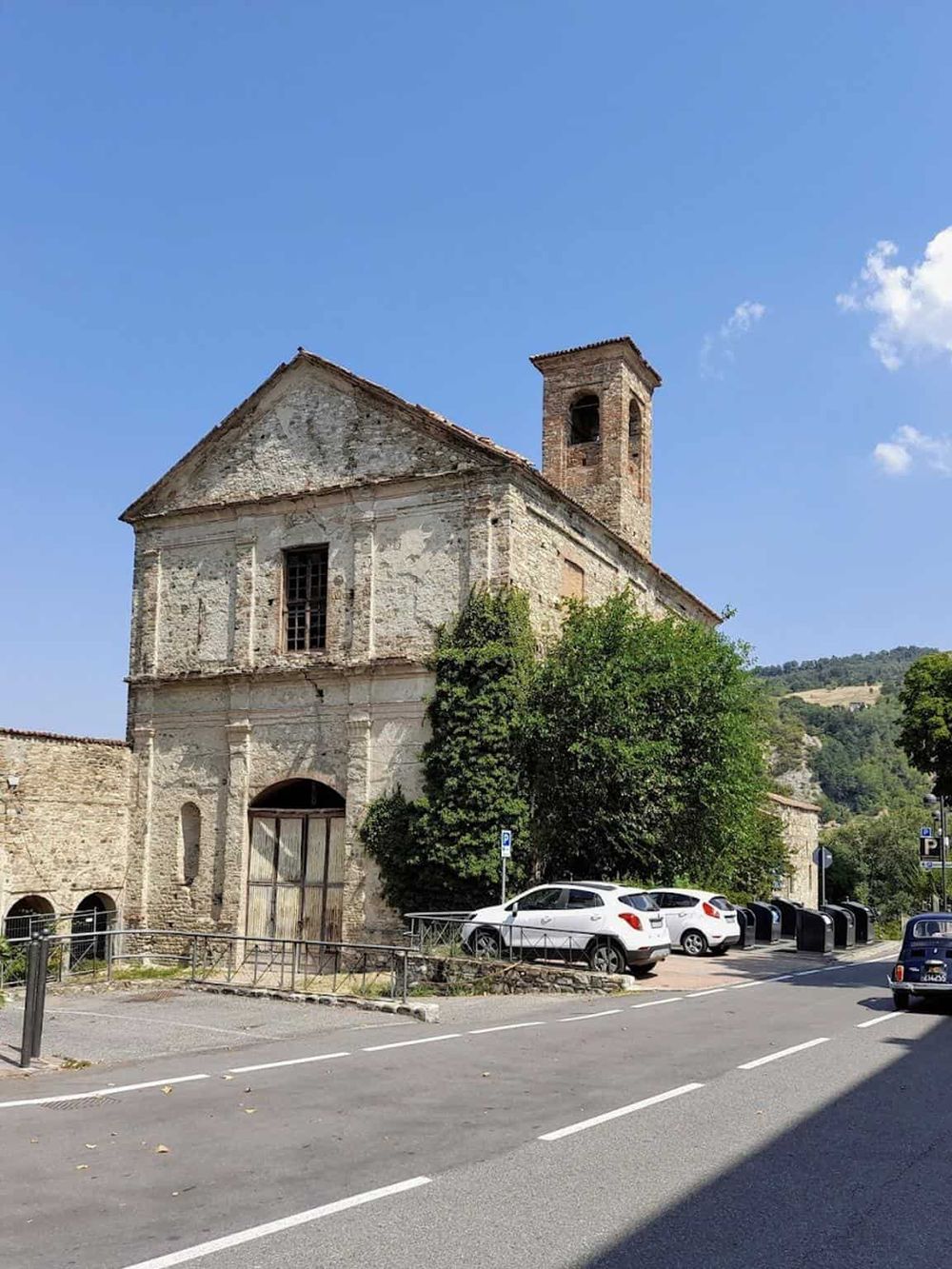 Ancient stone church building with bell tower in scenic outdoor setting, ideal for travel destinations.