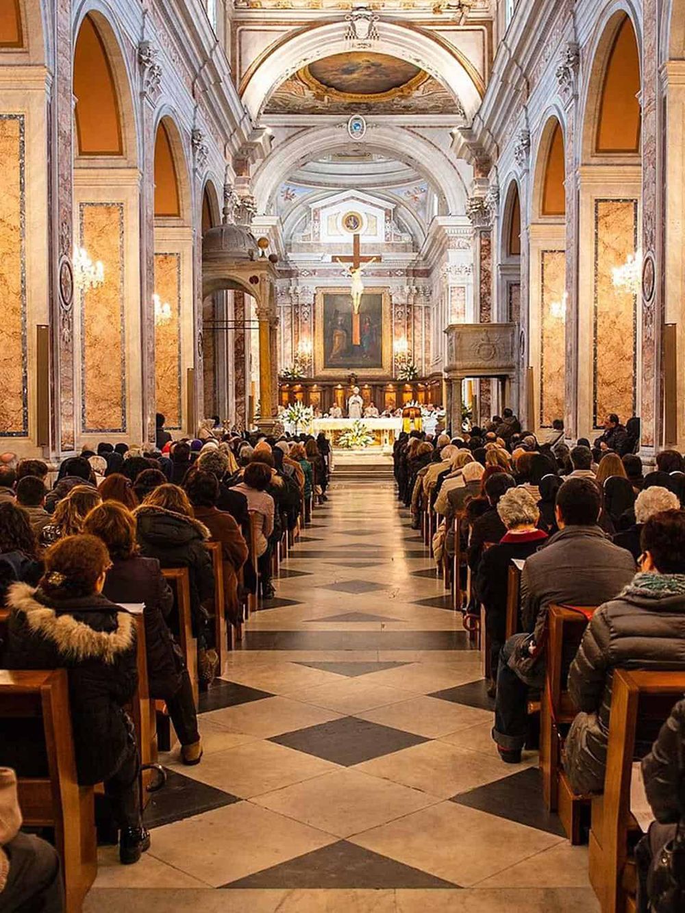 Vatican City church interior with congregation for mass or service, detailed ornate architecture and religious artwork.