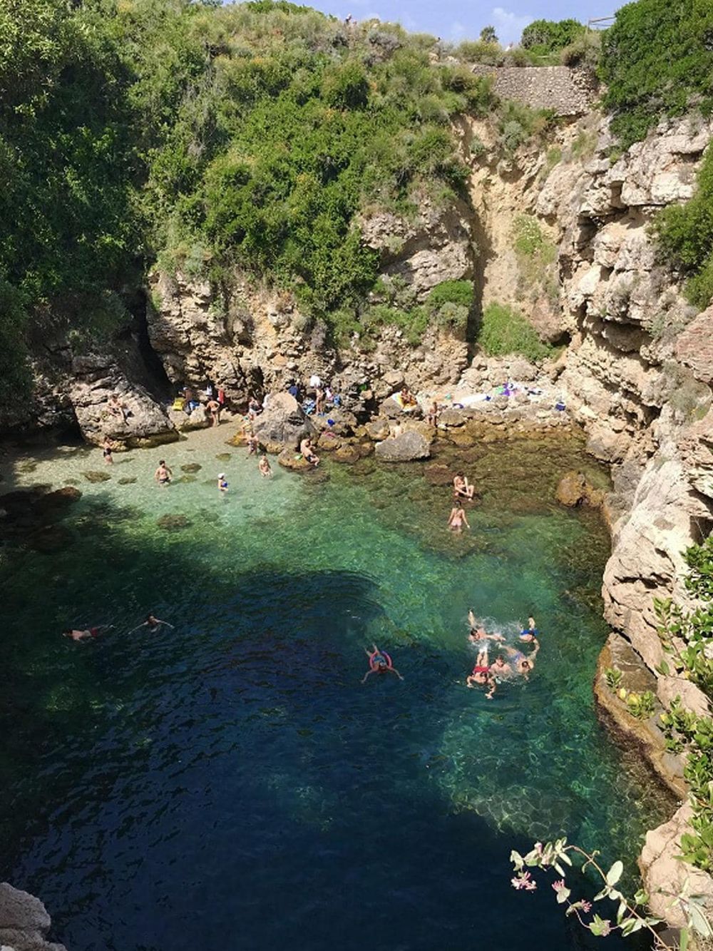 Hidden lagoon swimming spot with lush greenery and clear waters, perfect for relaxation and adventure.