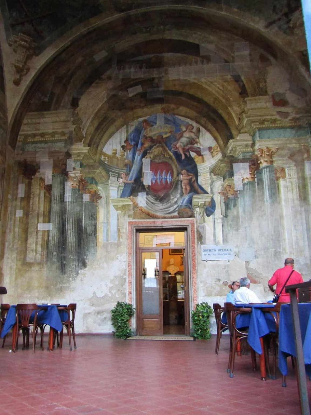 Vatican City interior with historic frescoes and elegant dining setup.
