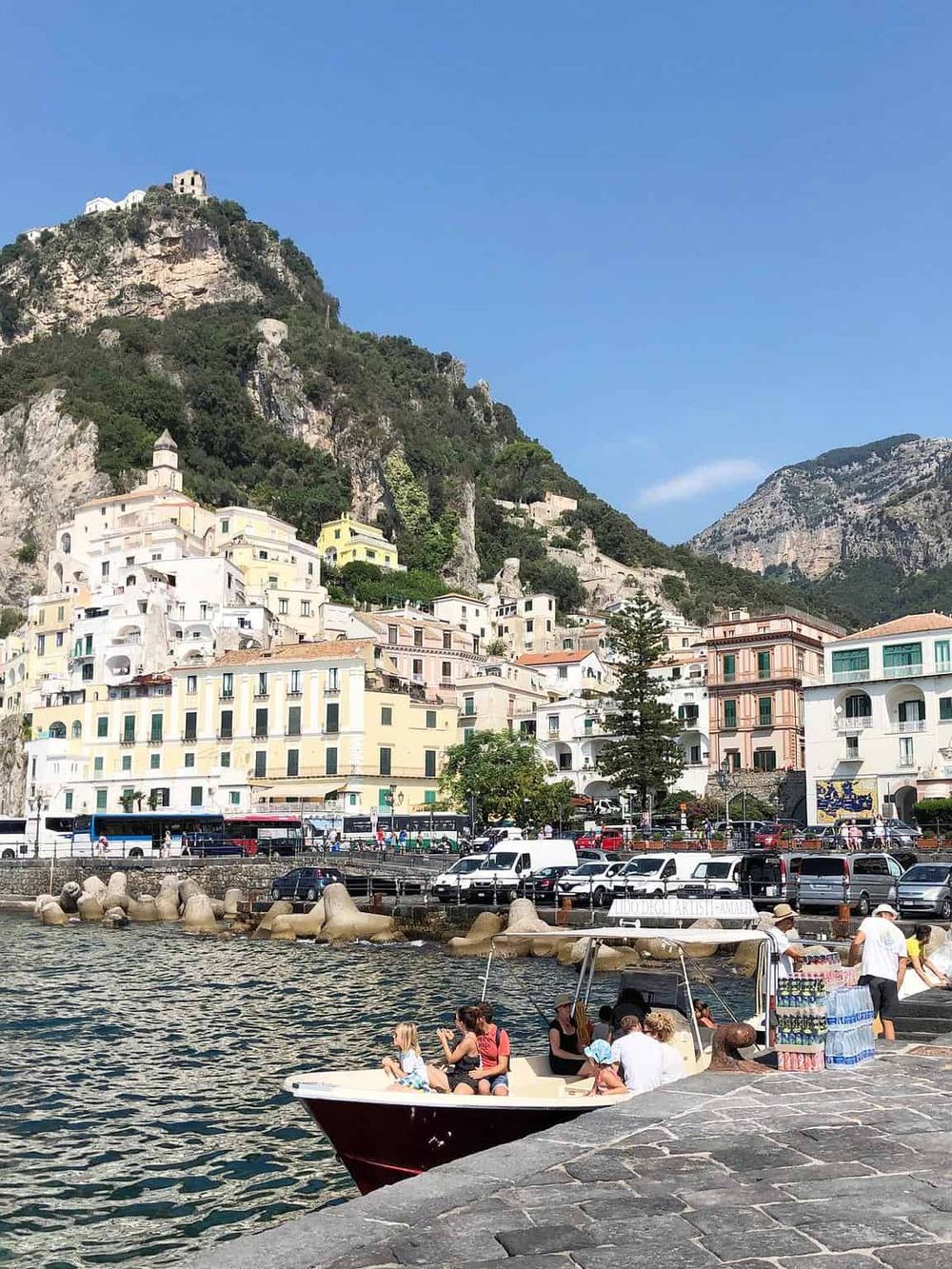 Colorful coastal town of Positano on the Amalfi Coast, Italy, with boats docked and scenic hillside architecture.