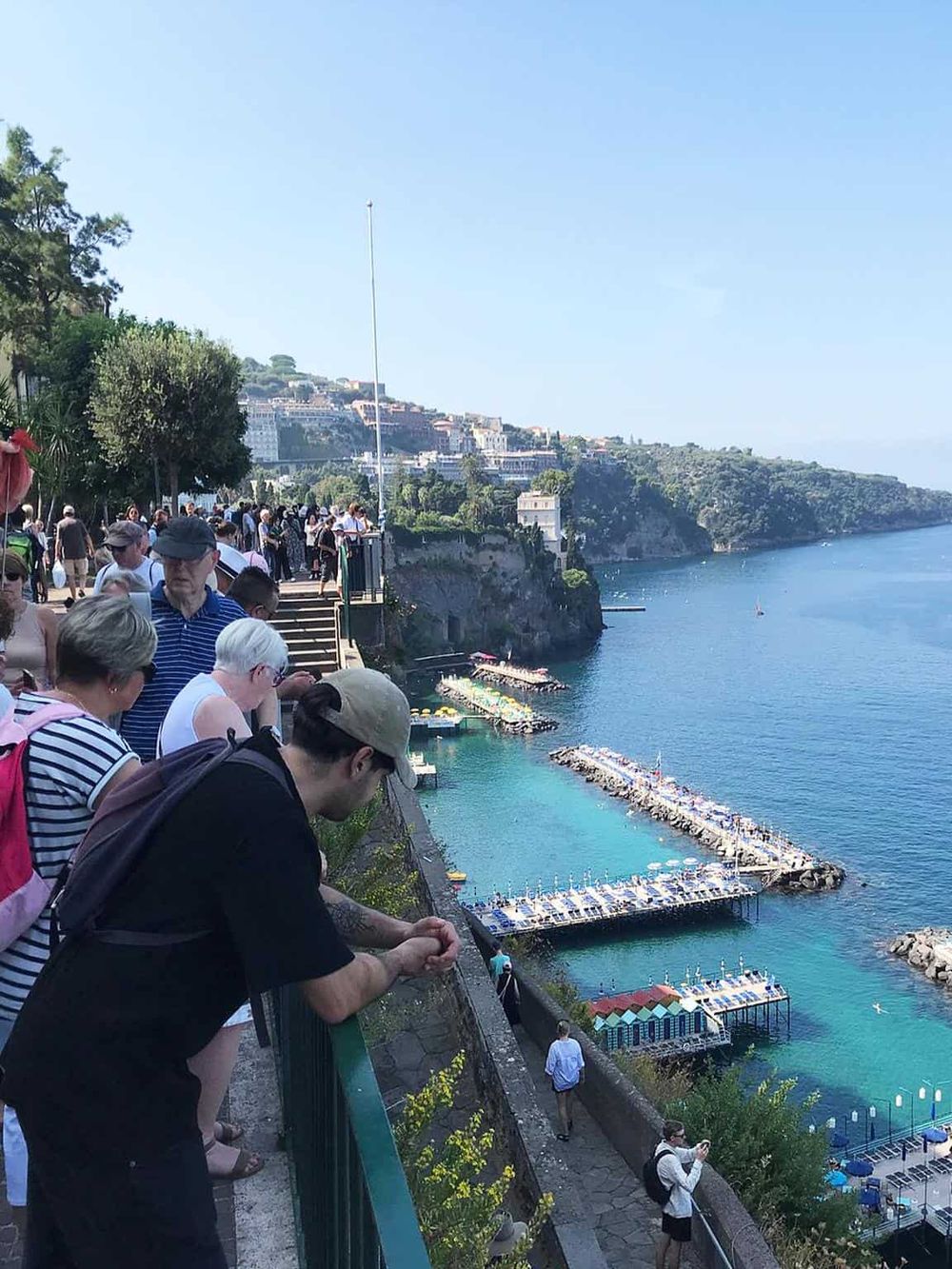 Breathtaking view of tourists overlooking Positano's coastal scenery and vibrant waterfront in Amalfi Coast, Italy.