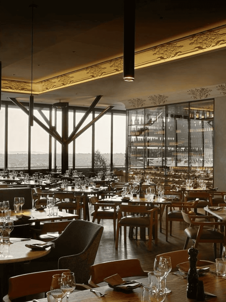 Modern upscale restaurant interior with large windows and elegant table settings, perfect for fine dining experiences.