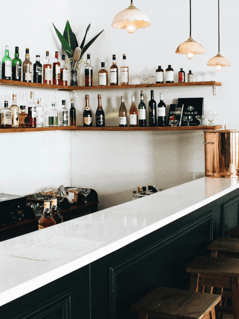 Aromatherapy and beverage bar with liquor bottles, modern decor, and cozy lighting for relaxing ambiance.