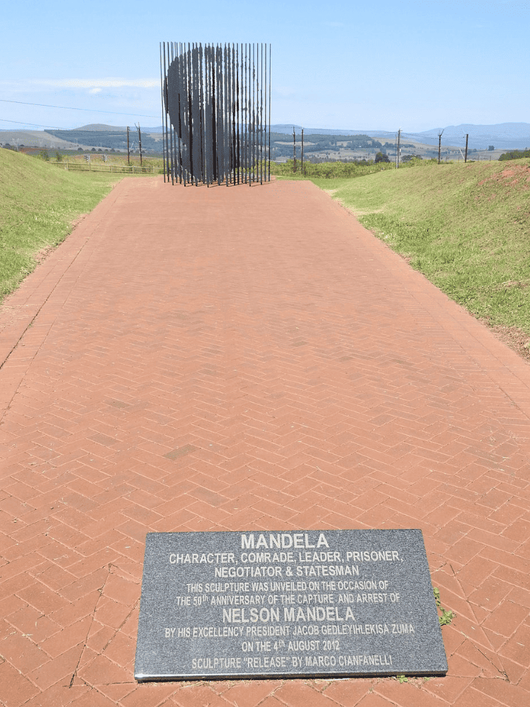 Heart sculpture memorial of Nelson Mandela in South Africa, overlooking scenic landscape and tribute plaque.