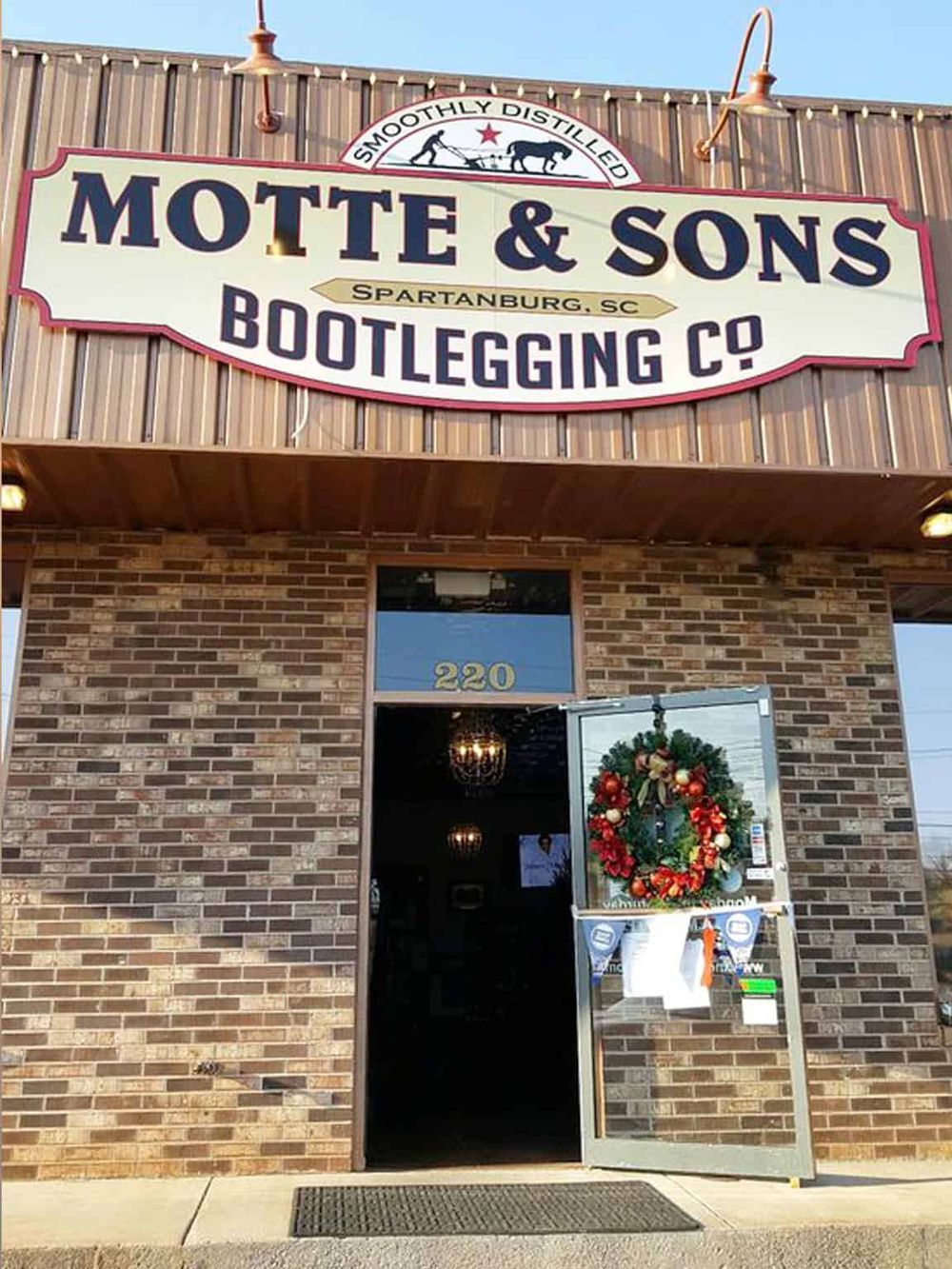 Handmade pottery studio sign with "Motte & Sons Bootlegging Co" in Spartanburg, SC. Discover unique pottery and artisan products.