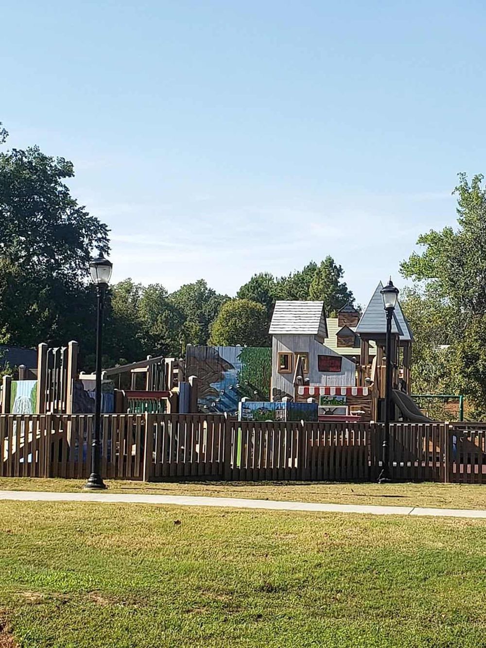 Colorful playground with trees and a blue sky background.