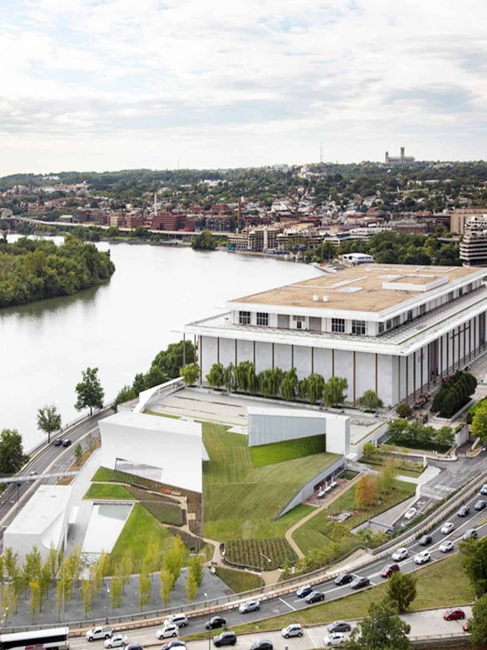 Modern cityscape with a river, innovative architecture, and green spaces, representing QuestForDirections' urban navigation solutions.