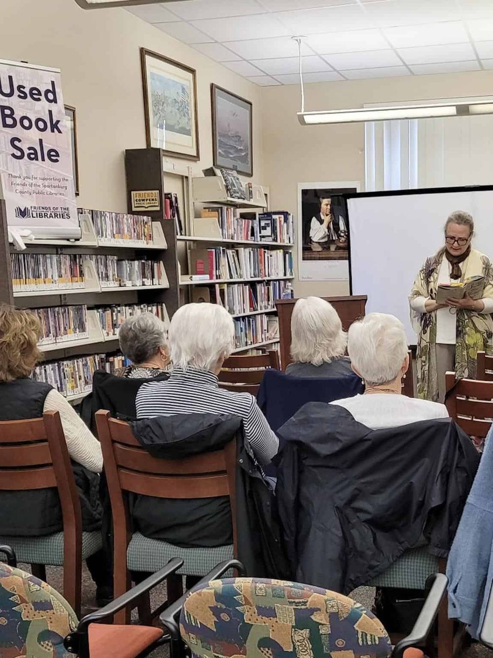 People attending a book reading event at a library.