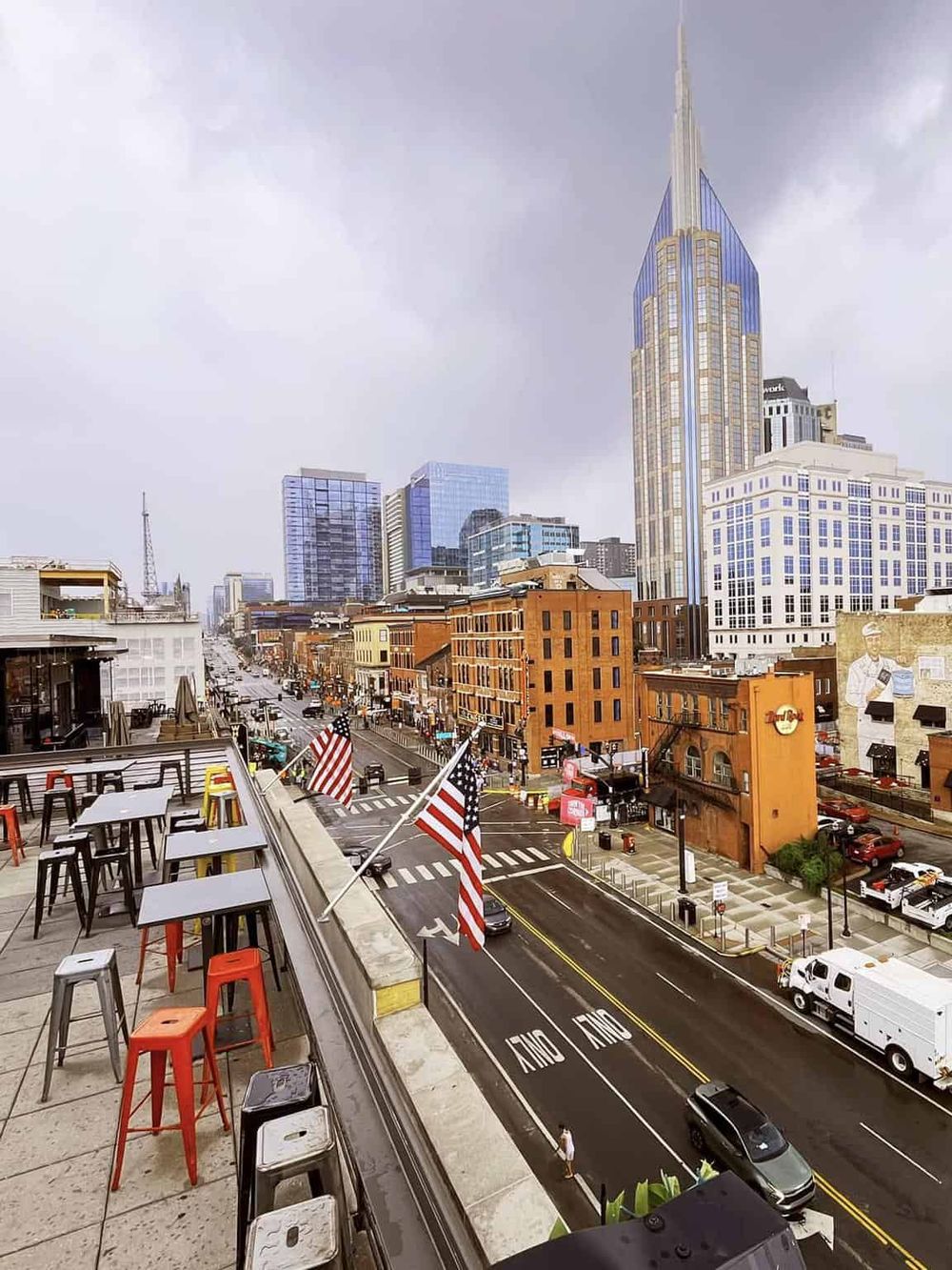Bright cityscape view of downtown Nashville from an outdoor rooftop bar, showcasing iconic skyscrapers and lively street scene.