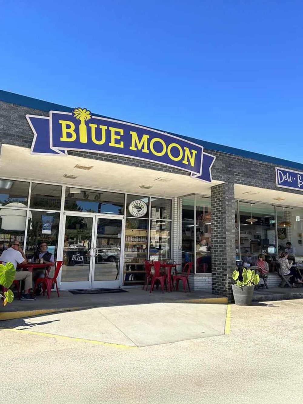 Bright blue sky over Blue Moon Restaurant, a popular dining spot with outdoor seating.