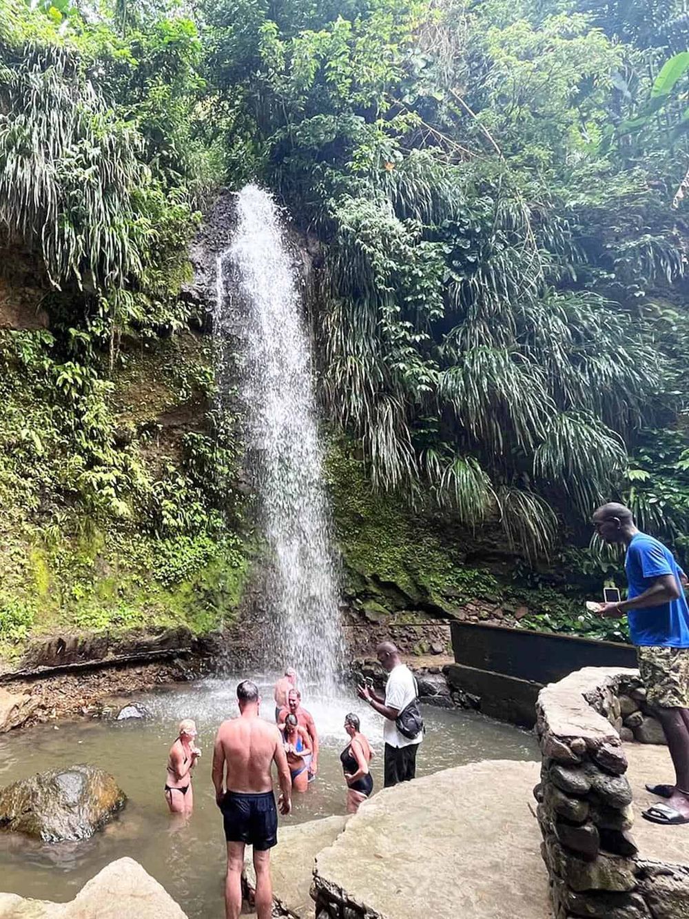 Waterfall adventure at lush jungle waterfall, swimming and exploring nature's beauty.