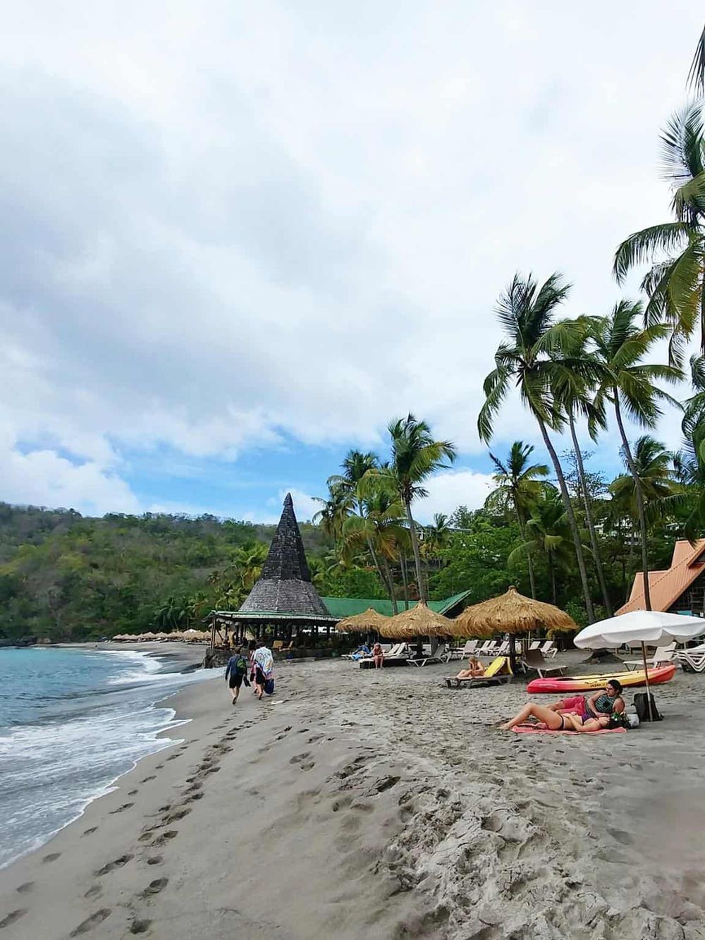 Paradise beach with palm trees and thatched umbrellas, perfect for relaxing and exploring nature.