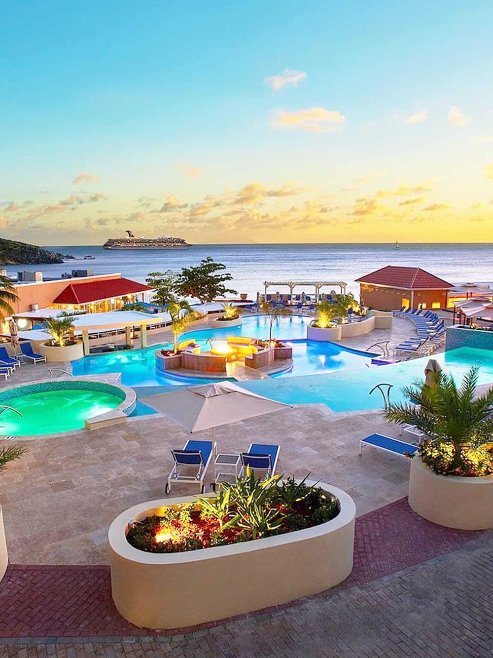 Relaxing ocean view at luxury resort with pool, hot tub, and sunset scenery in the Caribbean.