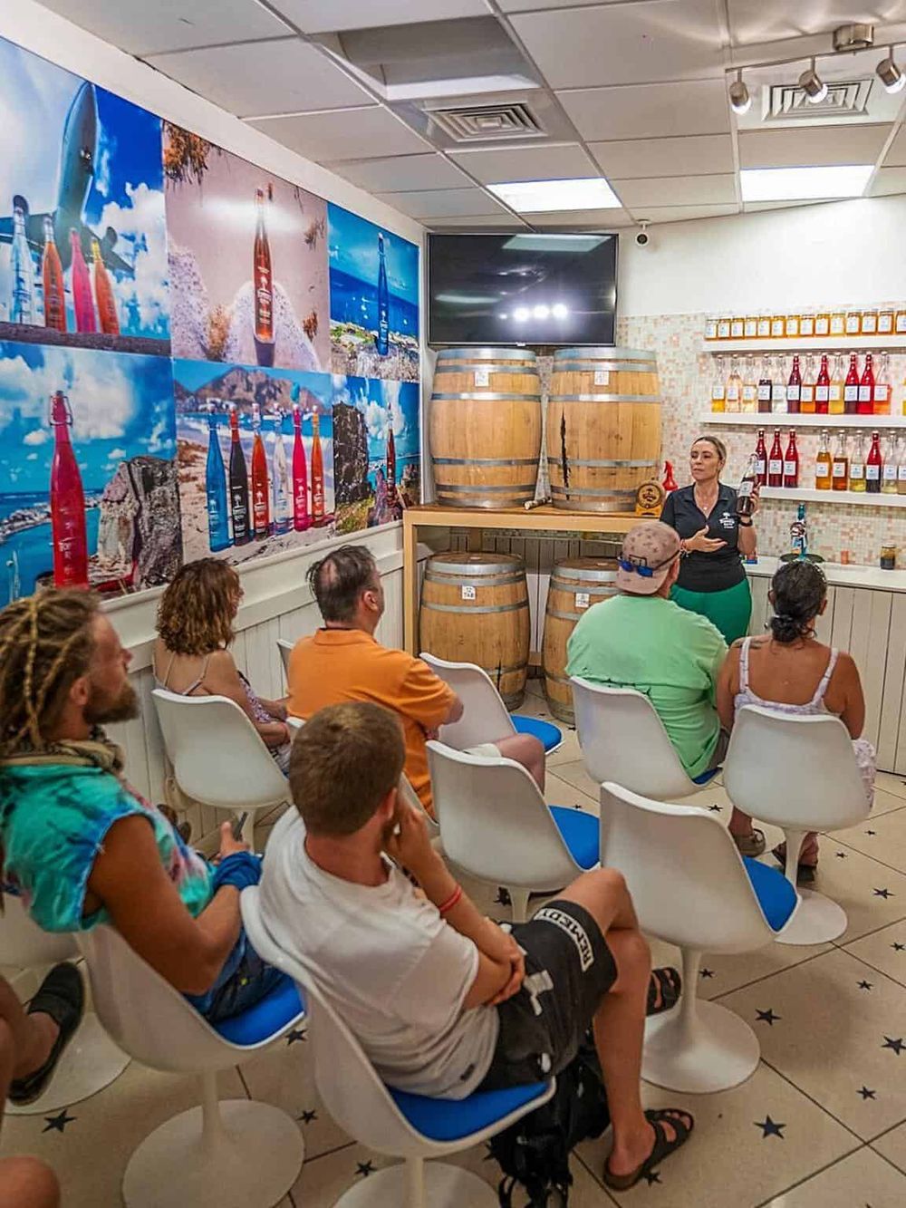 Colorful beach-themed mural with bottles and barrels at QuestForDirections, a local distillery tasting room.