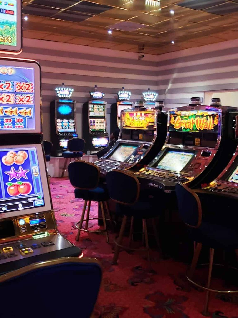 Bright casino gaming machines inside QuestForDirections, showcasing a lively gambling environment.