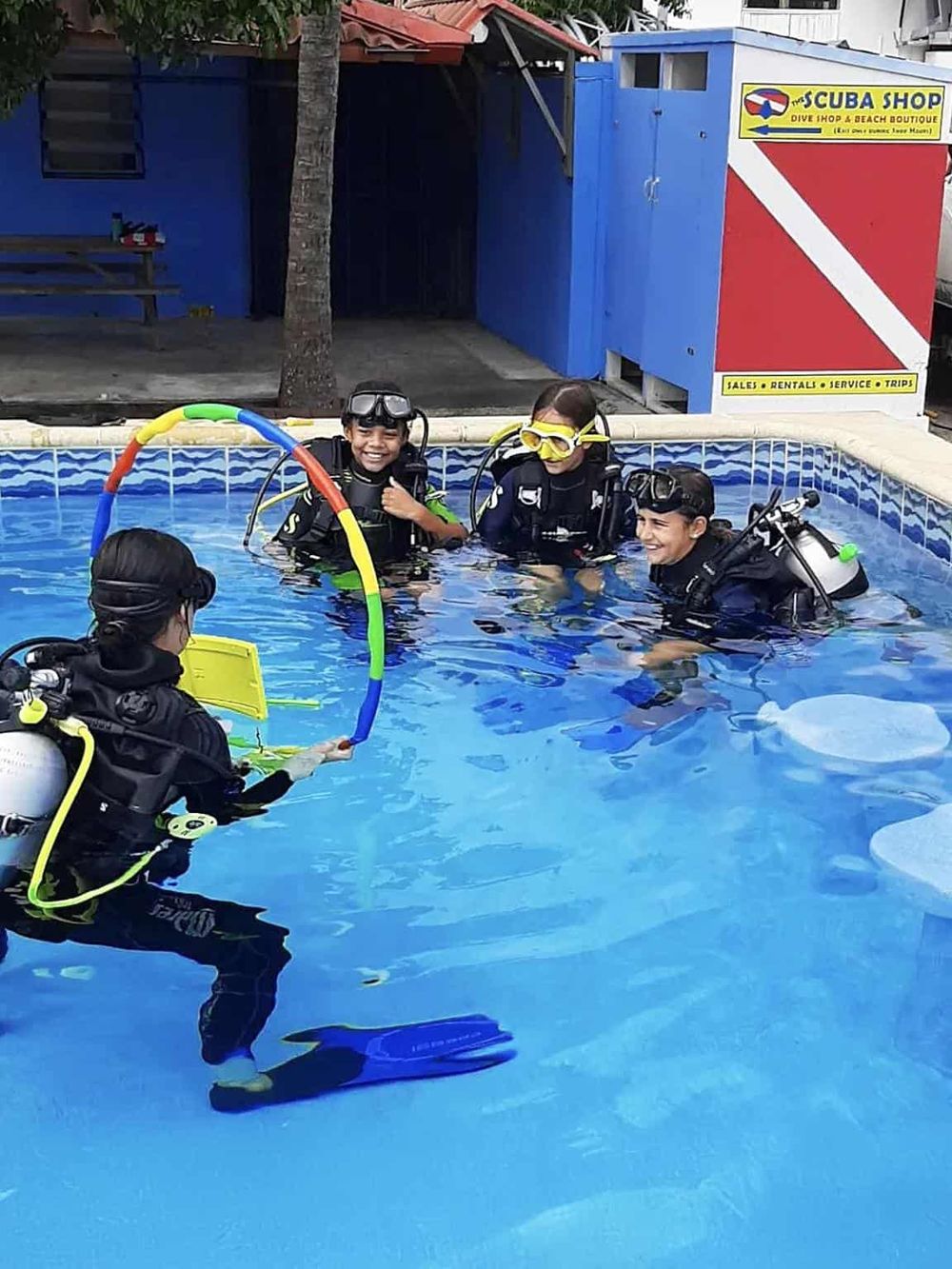 Children enjoying scuba diving class at a swimming pool, learning safety and techniques from professional instructors.