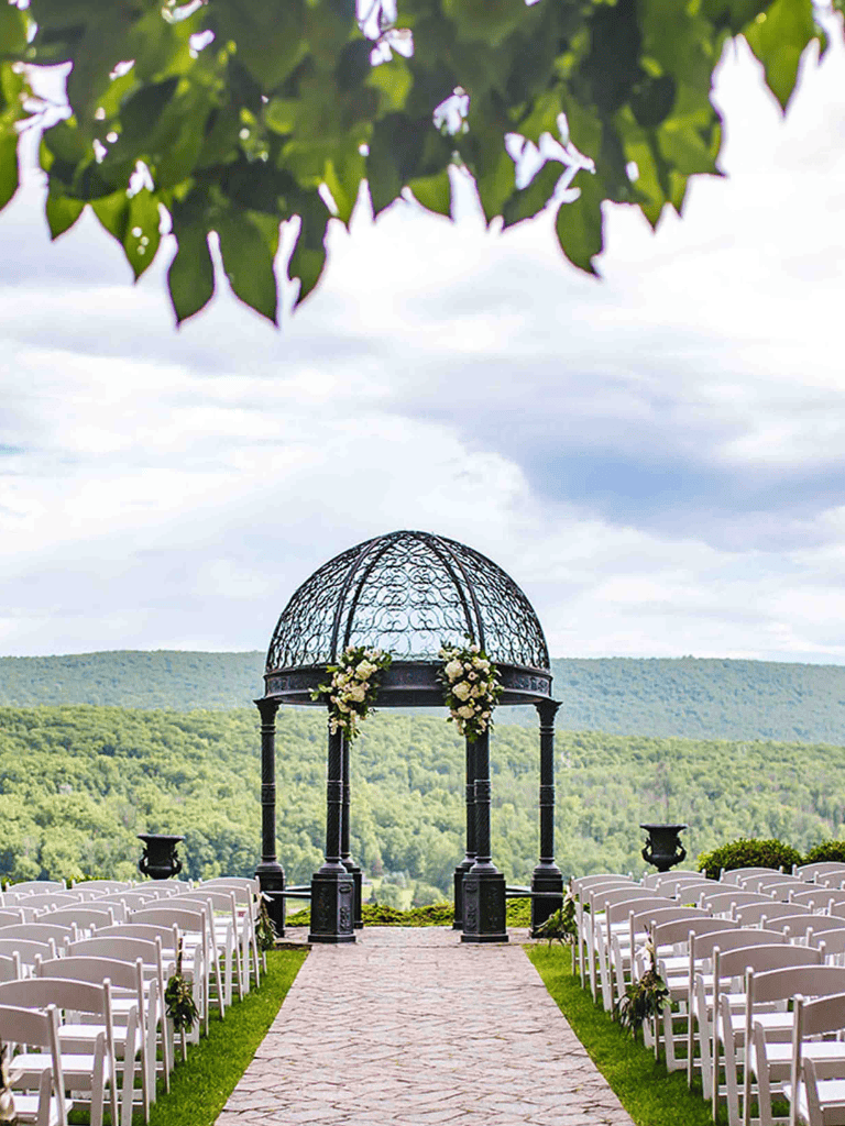 Elegant outdoor wedding ceremony setup with a decorative gazebo overlooking scenic mountain views.