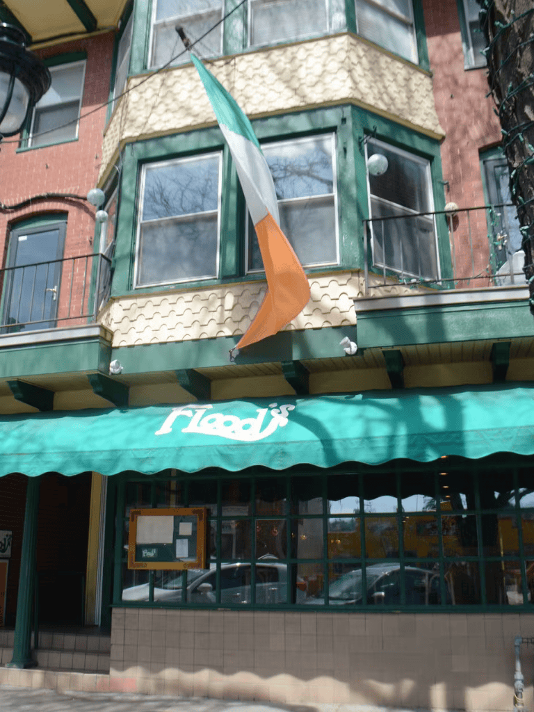 1. Irish flag outside Irish pub, cozy balcony, downtown ambiance.