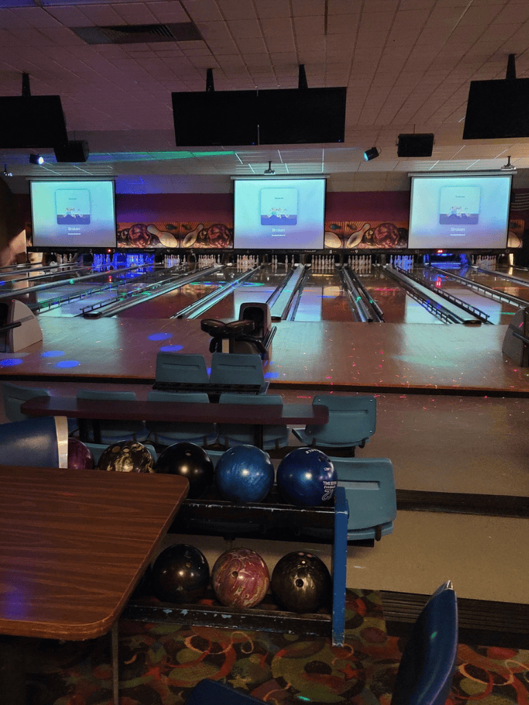 1. Modern bowling alley with multiple lanes, large screens, and colorful lighting.