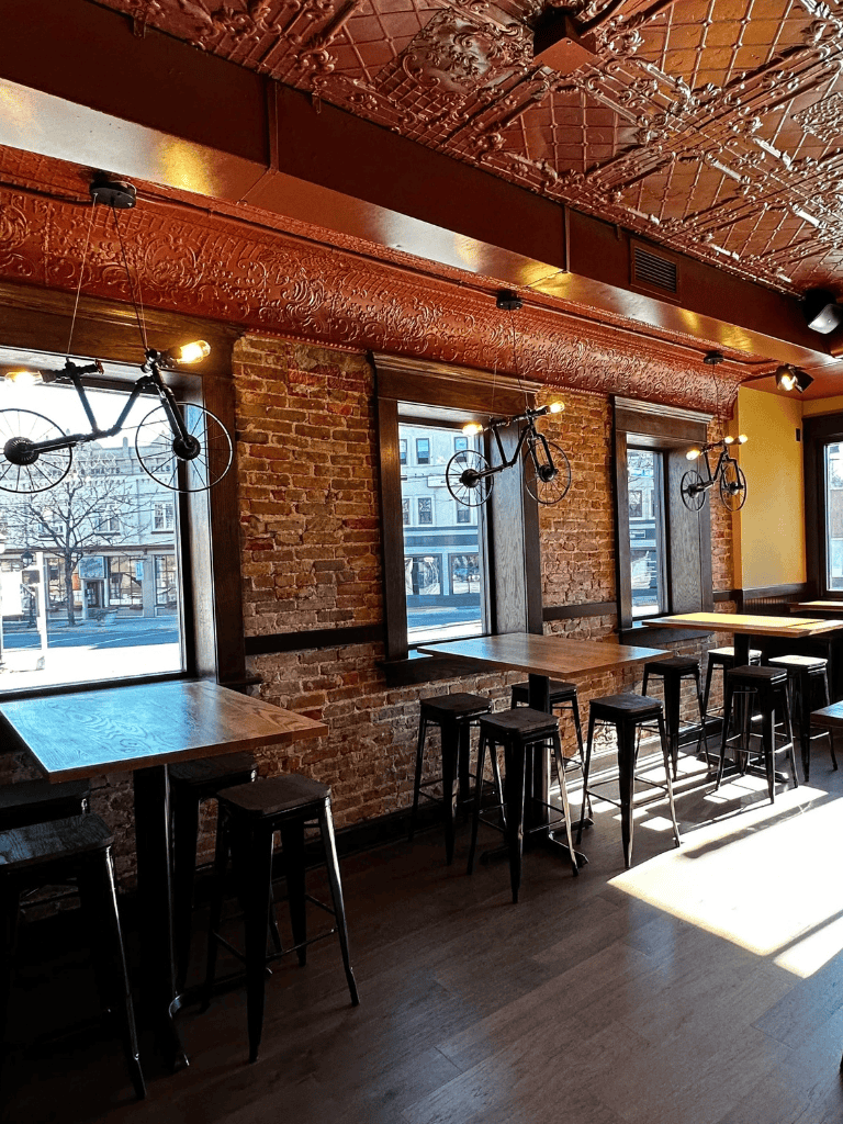 Vintage bike wall decor in cozy cafe with brick walls and large windows.