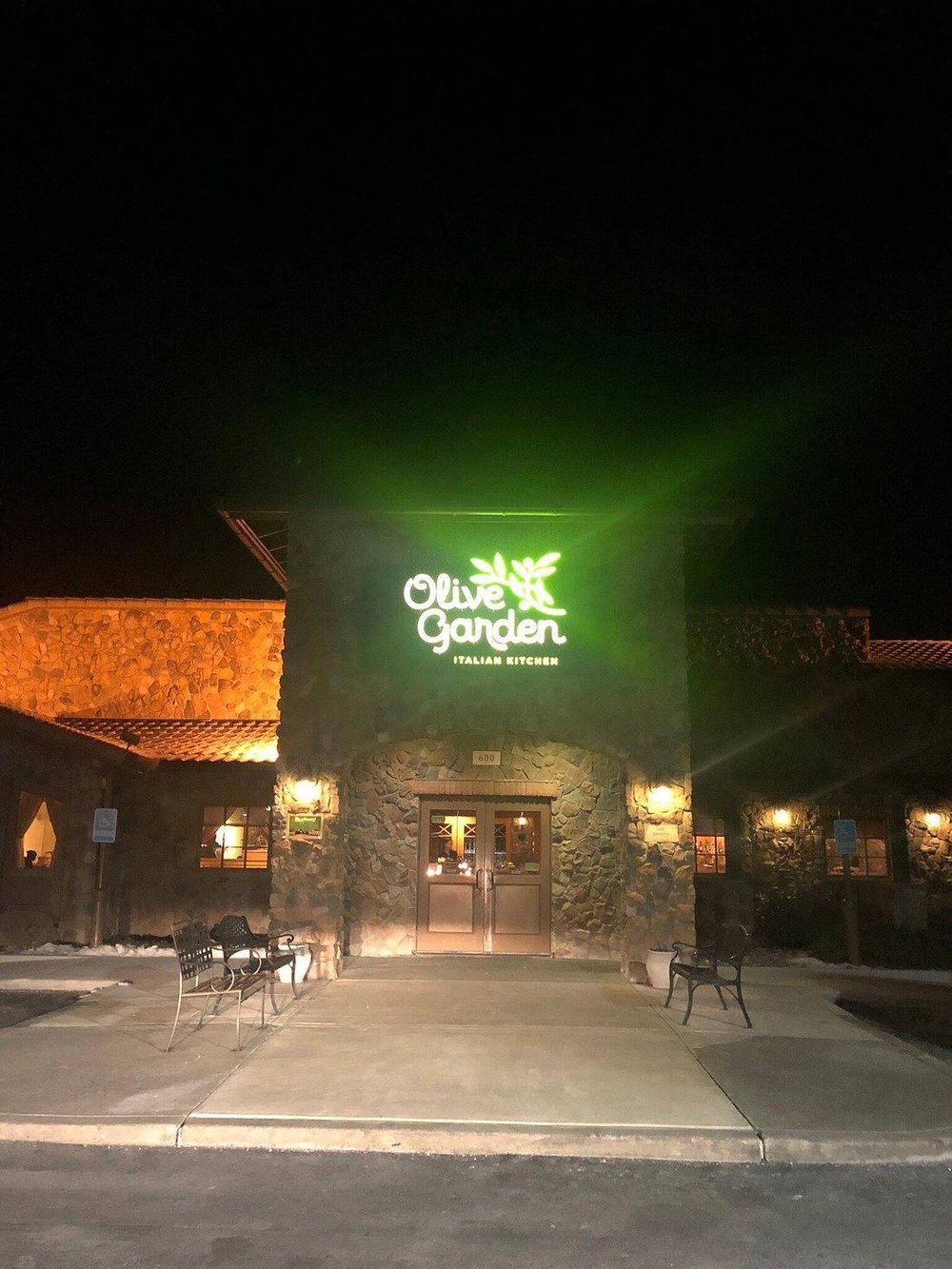 Charming Italian restaurant exterior at night, illuminated Olive Garden sign, inviting atmosphere for dining.