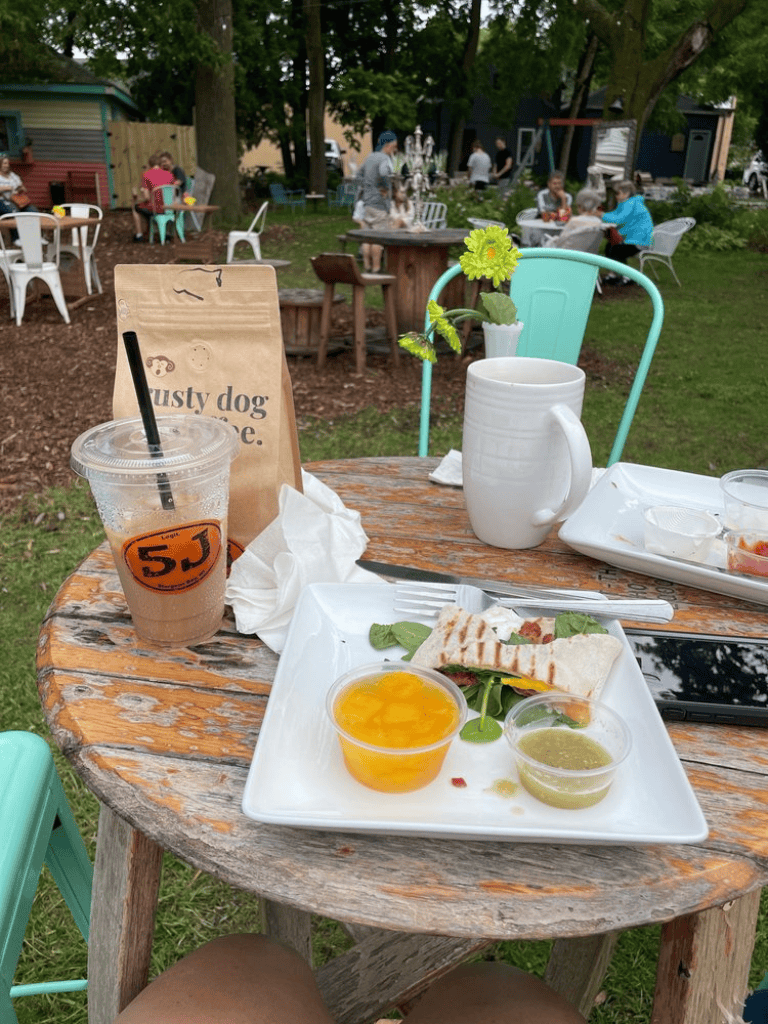 Fresh outdoor cafe meal with salad, drinks, and lively garden setting - perfect for relaxing and enjoying quality time.