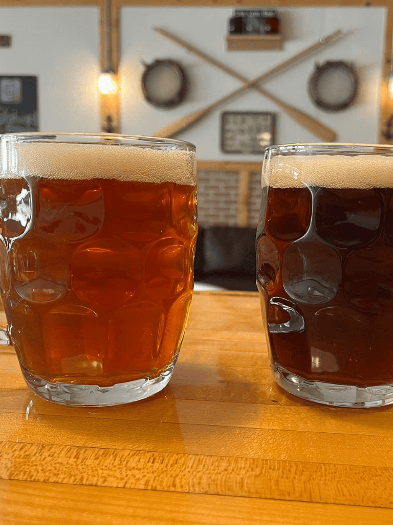 Refreshing craft beers in unique textured glasses at a cozy bar setting.