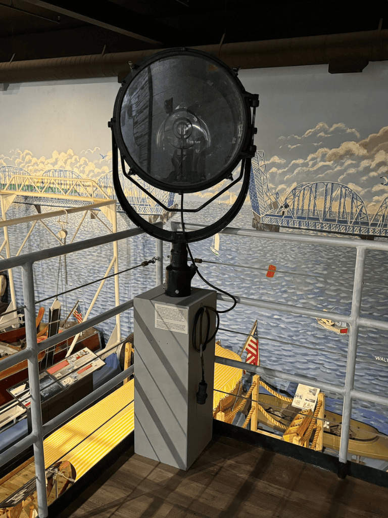 Flashlight on ship deck at maritime museum, coastal background, historic ships, nautical exploration.