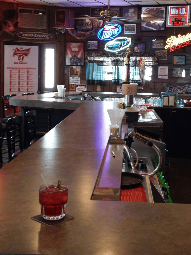 1. Cozy bar interior with neon lights, drink menu, and vintage decor for a casual night out.