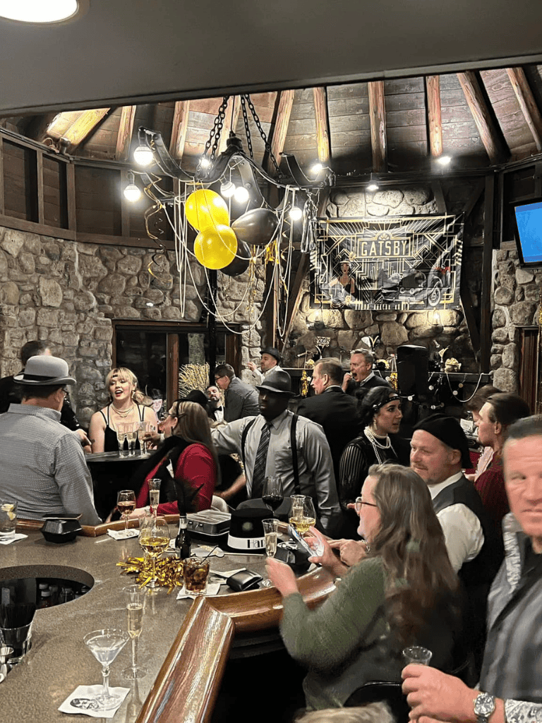 Celebration at Gatsby-themed event with vintage attire, lively atmosphere, and elegant drinks.