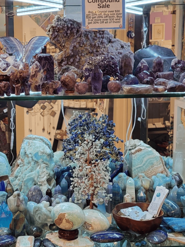 Blue and purple mineral specimens with decorative items in a crystal shop.