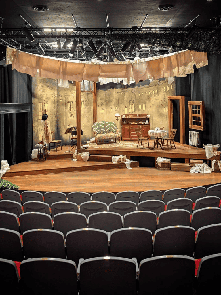 Vintage theater stage set with cozy, rustic decor and theater seating, ideal for creative performances and community events.