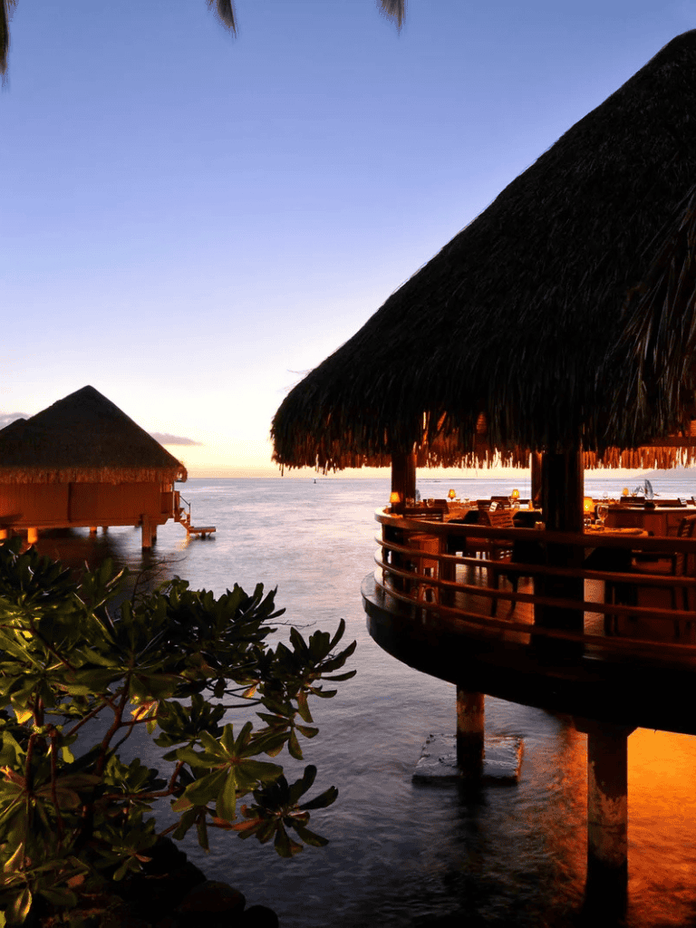 Overwater bungalow at sunset in a tropical resort for a dreamy vacation experience.