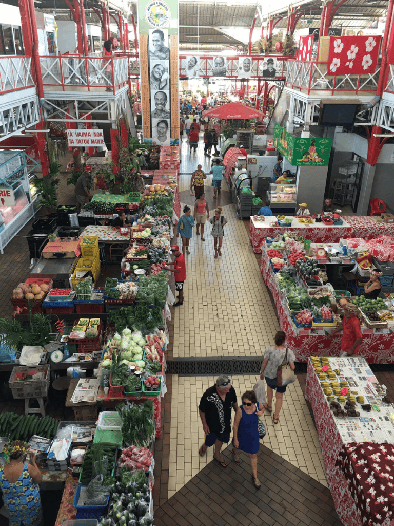 Fresh produce market at QuestForDirections shopping mall, vibrant stalls and shoppers, diverse fruits and vegetables, indoor marketplace.