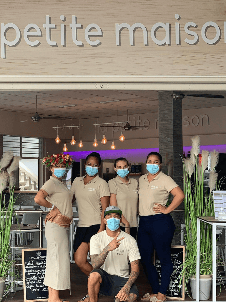 Delicious petite maison bakery staff wearing masks in modern cafe ambiance.