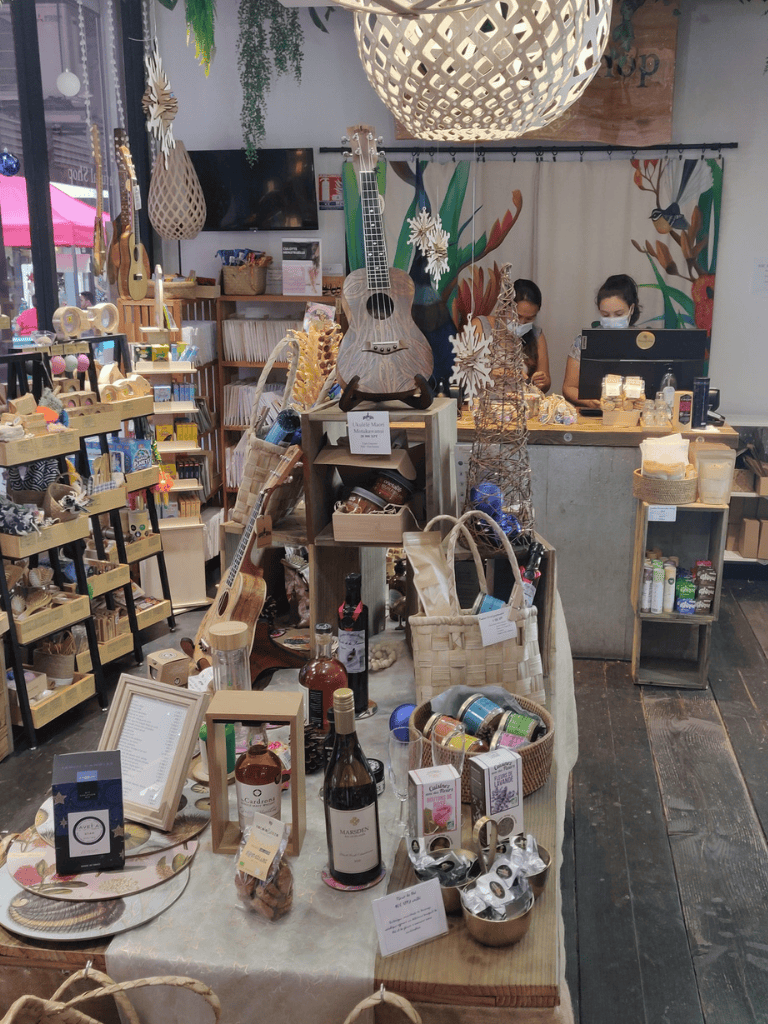 Handmade gift shop with local artisan products, such as jewelry, candles, and wines, in a cozy boutique setting.