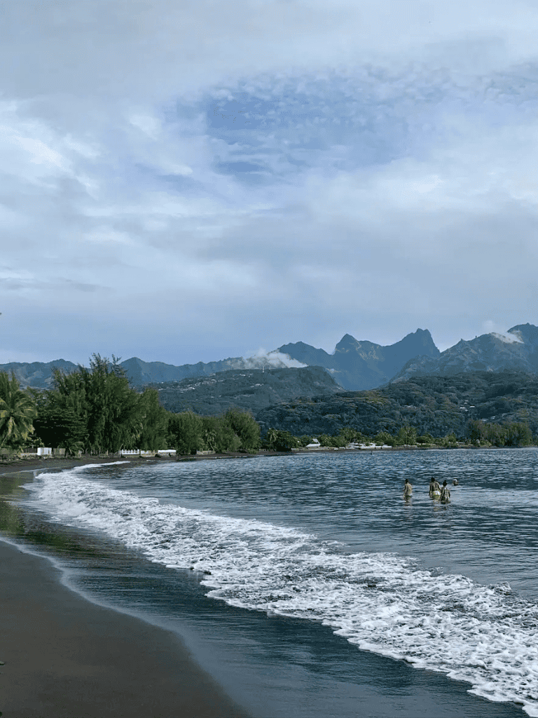 Relaxing beach scenery with mountains in the background, ideal for travel & adventure planning.
