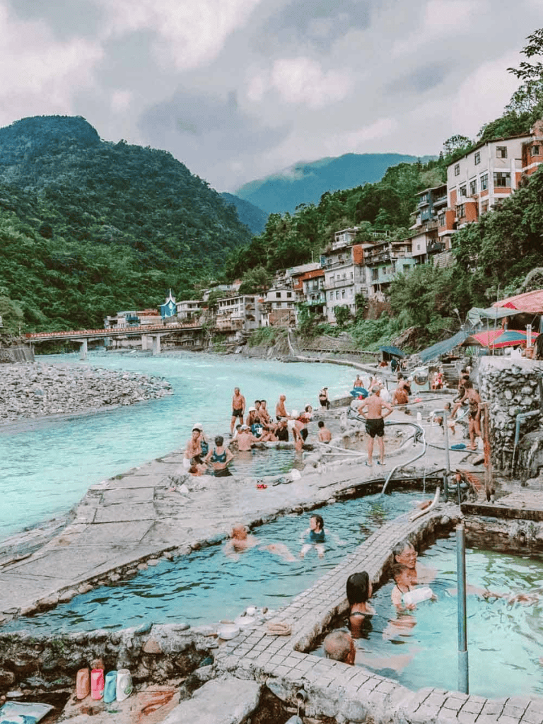 Relaxing riverside hot springs with mountain views in a scenic village setting.