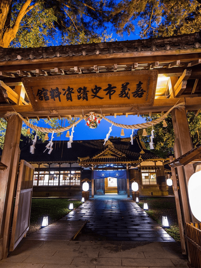 Ancient Japanese temple gate illuminated at twilight, traditional architecture and cultural heritage.