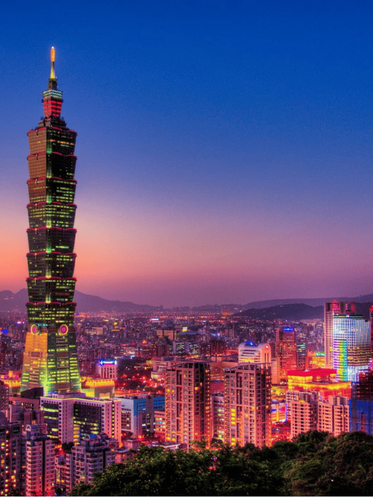 Colorful Taipei 101 skyscraper illuminated at dusk in Taiwan.