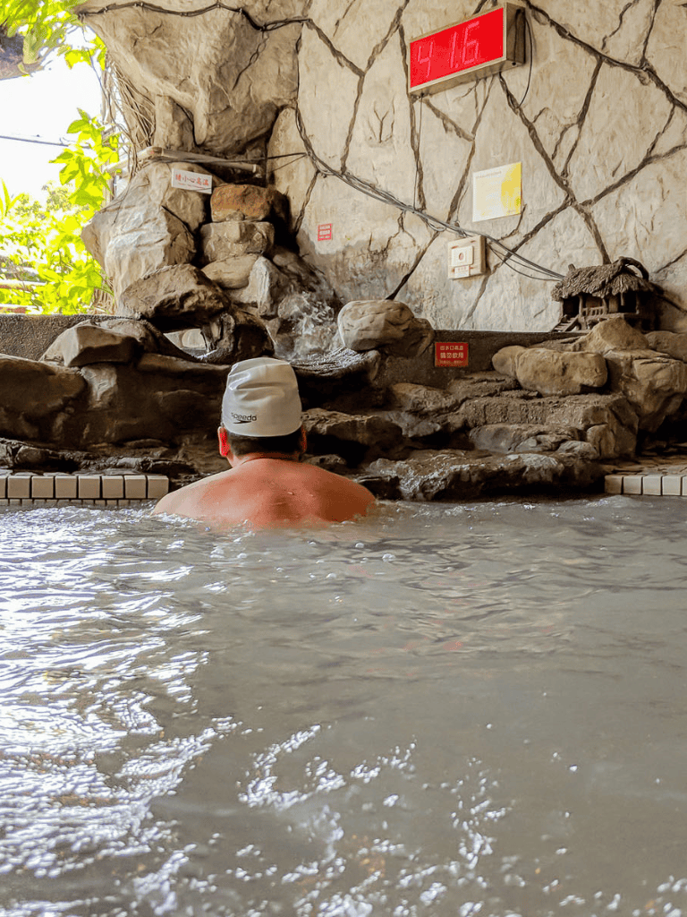 Soaking in mineral-rich hot spring water with natural rock surroundings.