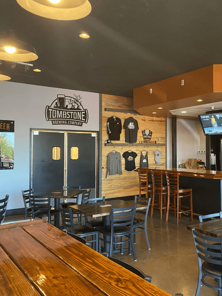 Tombstone Brewing Company indoor bar and seating area with merchandise display.