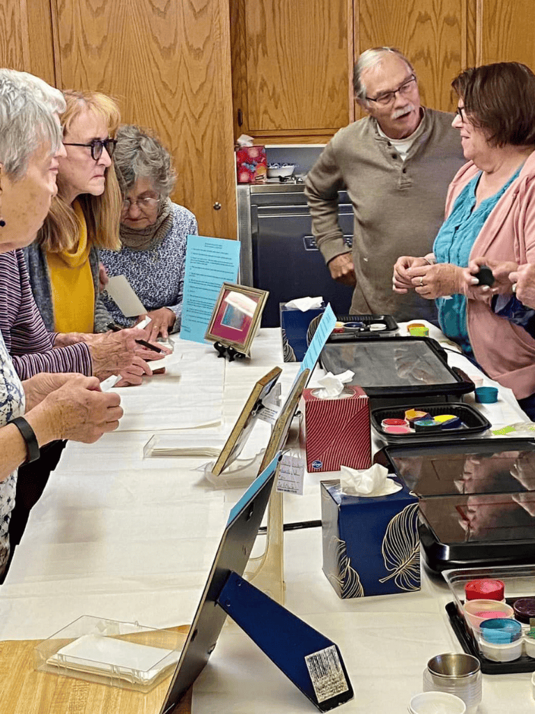 Comfortable senior group engaging in a crafting activity at a community center or workshop.